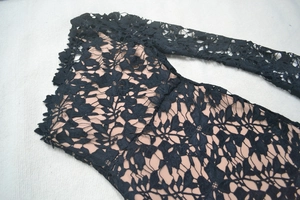 Detailed close-up of intricate black floral lace with nude lining on evening dress