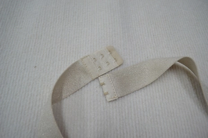 Détail du tissu pailleté champagne et de la fermeture à crochets à trois rangs du dos