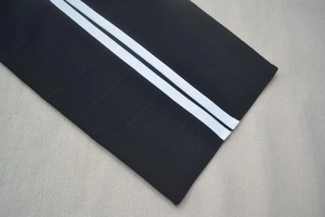 Detail of black bandage dress showing elastic fabric texture and white stripes