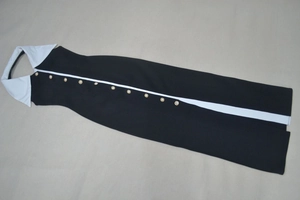 Détail du col contrasté avec boutons perlés sur une robe midi moulante noire et blanche