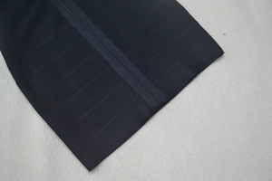 Détail de la robe bandage noire montrant la texture en maille côtelée haute élasticité