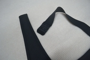 Détail de la fermeture à trois rangées de crochets sur robe bandage noire élastique