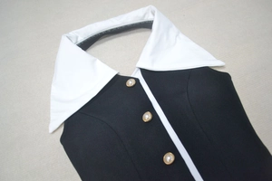 Détail du col contrasté noir et blanc élégant avec boutons perle sur robe bandage