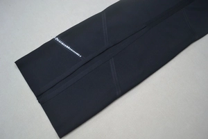 Vue détaillée des ornements en strass sur la couture d'une robe bandage noire licou