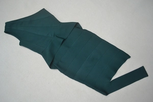 Detail of dark green bandage dress with elastic textured horizontal compression bands