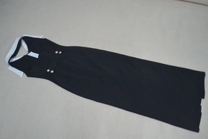 Détail du col blanc contrasté et des boutons perlés sur la robe longue noire chic