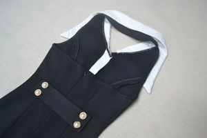 Détail du col blanc contrasté et boutons de perles sur la robe noire ajustée chic