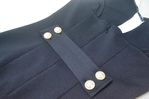 Détail de la robe en tricot noir avec boutons de perles élégants et fermeture éclair invisible