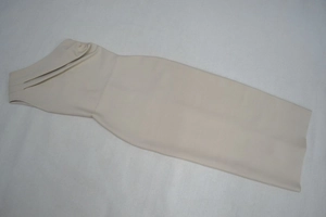 Détail d'une robe bandage beige à une épaule avec des plis élégants au niveau du décolleté
