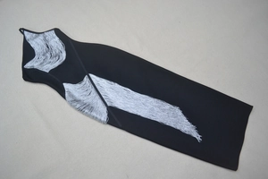 Détail des franges argentées sur une robe bandage noire sans manches ajustée