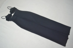 Detailed flat lay of black bodycon dress featuring structured bust and high back slit
