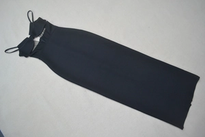 Flat lay of a black bodycon dress featuring sheer mesh panels and delicate spaghetti straps