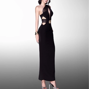 Detail of waist cutout with black mesh patchwork and a gold metallic buckle on black dress