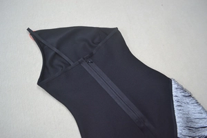 Détail de robe bandage noire avec finitions à franges argentées et fermeture éclair dos
