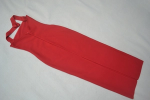 Dettaglio dell'abito bandage rosso con allacciatura al collo e spacco sull'orlo posteriore