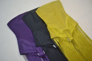 Detailed view of tiered fringe tassels on sleeveless party dresses in multiple colors