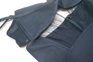 Detail of black ribbed fabric with sheer mesh panels and high-quality zipper closure