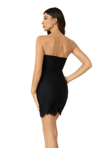 Détail de la robe bandage noire sans bretelles avec ourlet en dentelle de cils et fermeture