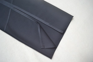Détail d'une robe bandage noire montrant la texture élastique et la fente au bas