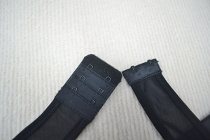 Close-up of a black mesh bandage dress featuring three-row metal hook and eye back closures