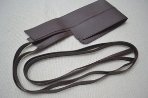 Dettaglio di una cintura a corsetto marrone scuro in ecopelle con lacci e cuciture rifinite