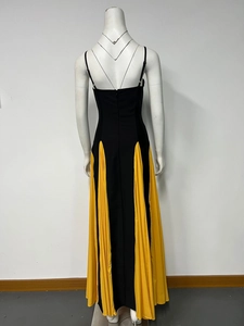 Detail of elegant backless dress featuring black body and contrast yellow pleated side panel