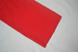 Vista dettagliata del tessuto rosso del vestito bandage con finiture di cucitura lisce