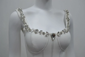 Détail d'une robe corset blanche avec bretelles en cristal et pendentif poire