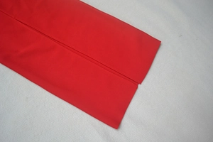 Dettaglio dell'abito bandage rosso che mostra le cuciture dell'orlo e il design dello spacco