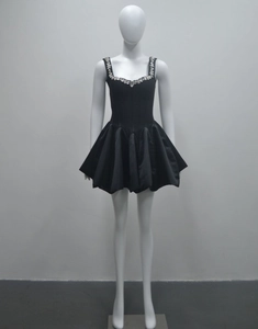 Détail du décolleté carré avec strass étincelants sur une mini robe bouffante noire