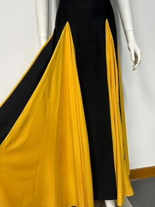 Detail of contrasting black and yellow pleated chiffon maxi dress with flowing hemline