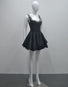 Détail de la robe noire courte avec décolleté en strass et jupe plissée volumineuse