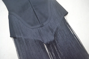 Close-up of fine black fringe detailing and dense fabric on the bodycon dress