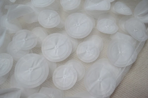 Detail view of layered 3D organza flower petals on white strapless evening party dress