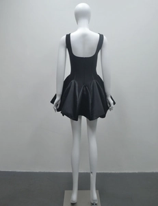 Vue arrière d'une mini-robe noire dos nu avec une jupe plissée volumineuse sur mannequin