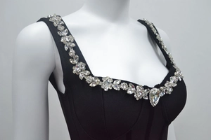 Détail de la robe corset noire avec broderie florale en strass et pendentif goutte