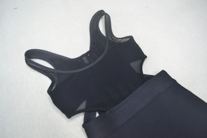 Détail de l'empiècement en maille noire sur un ensemble haut de sport et jupe ajusté
