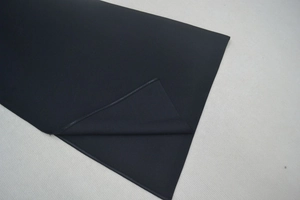Gros plan sur tissu noir avec coutures renforcées et détails de texture au dos