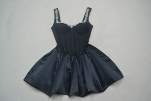 Détail de mini-robe corset en satin noir avec bretelles en strass et structure baleine