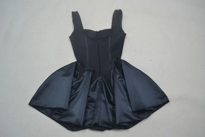 Détail à plat d'une robe noire à col carré mélangeant des tissus maille et satin