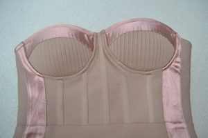 Détail de corset beige montrant le tissu côtelé, empiècements satin et maintien bonnet