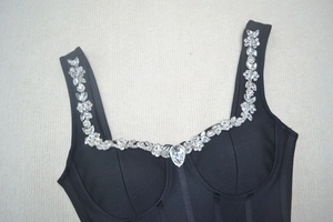 Détail des strass en cristal et des motifs floraux sur le corsage noir de la robe