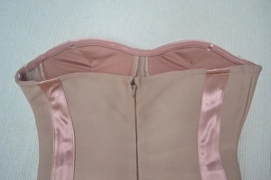 Détail d'une robe bandage nude avec fermeture éclair invisible et bande en silicone
