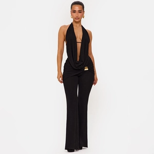 Detailansicht vom schwarzen Neckholder-Jumpsuit mit V-Ausschnitt und Goldschnalle