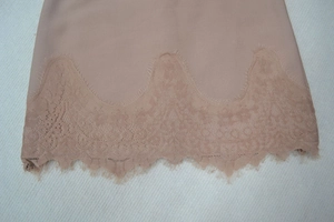 Détail macro du tissu côtelé rose poudré et de la bordure en dentelle cil délicate