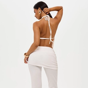Detail von weißem rückenfreiem Halterneck-Top und High-Waist-Hose mit Falten