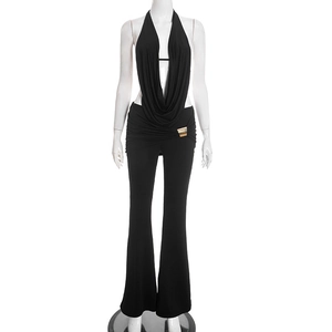 Detail von schwarzem Neckholder-Top mit goldener Metallschnalle und Schlaghose im Set