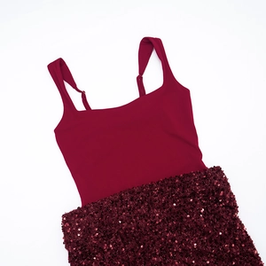 Détail de la robe sans manches bordeaux avec corsage mat et patchwork de paillettes brillantes