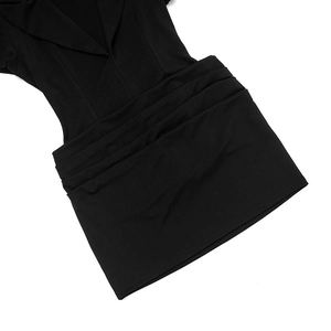 Detail of elegant black V-neck mini dress showing ruched pleated texture and lapel