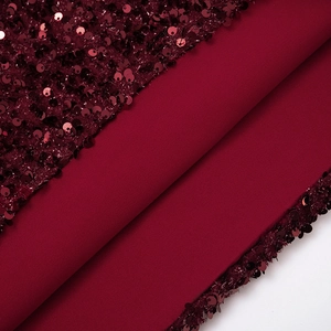 Détail macro de broderies à paillettes rouge vin sur tissu épais pour robe de soirée